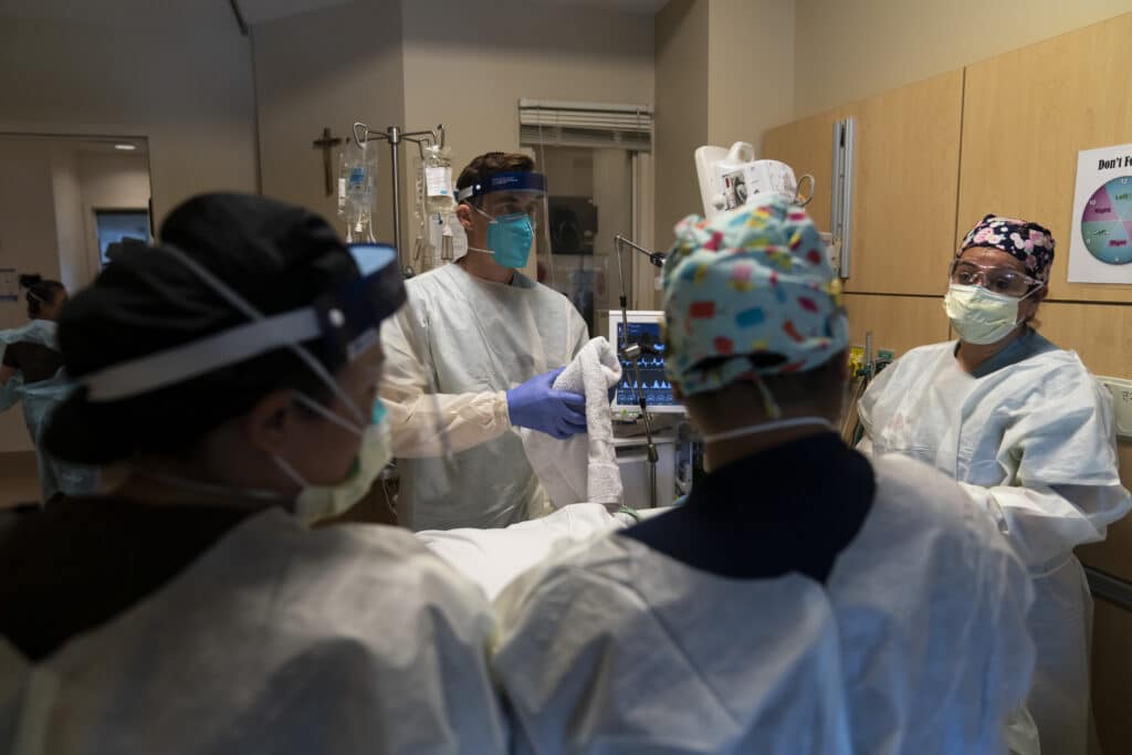 medical personnel prepare to prone a COVID-19 patient at Providence Holy Cross Medical Center