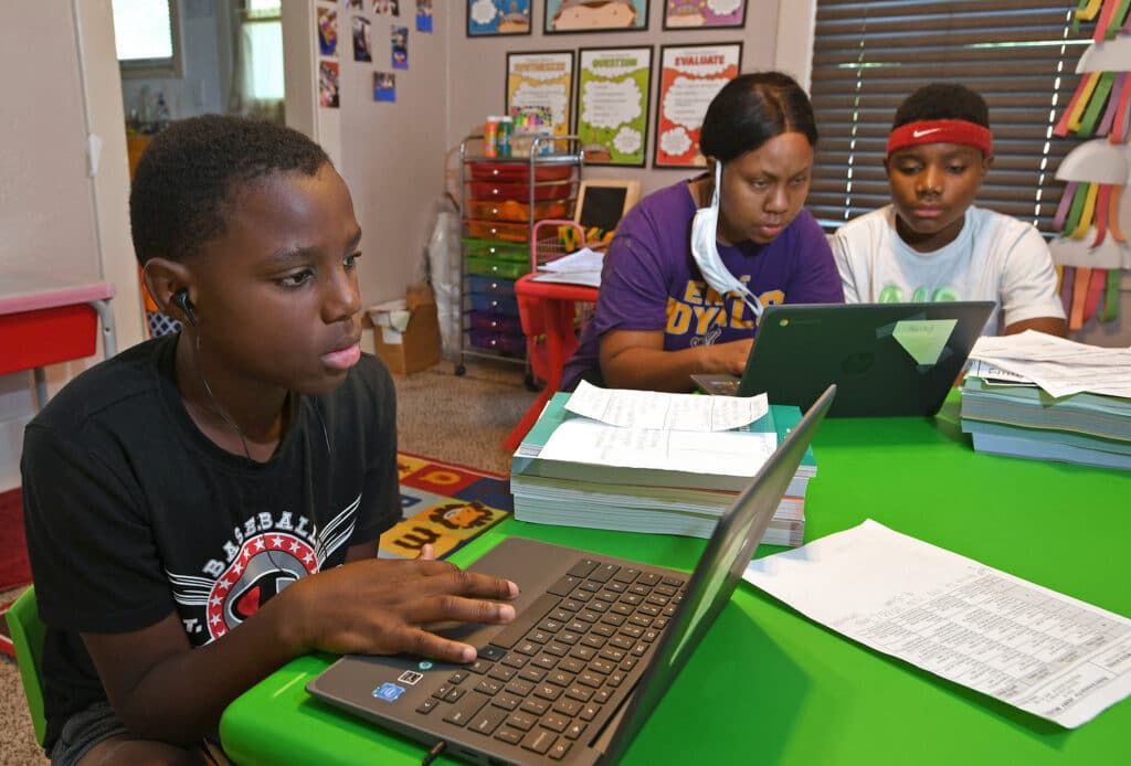 Michael Henry, 11, left, his mother Mary Euell, center, and his 12-year-old brother Mario Henry