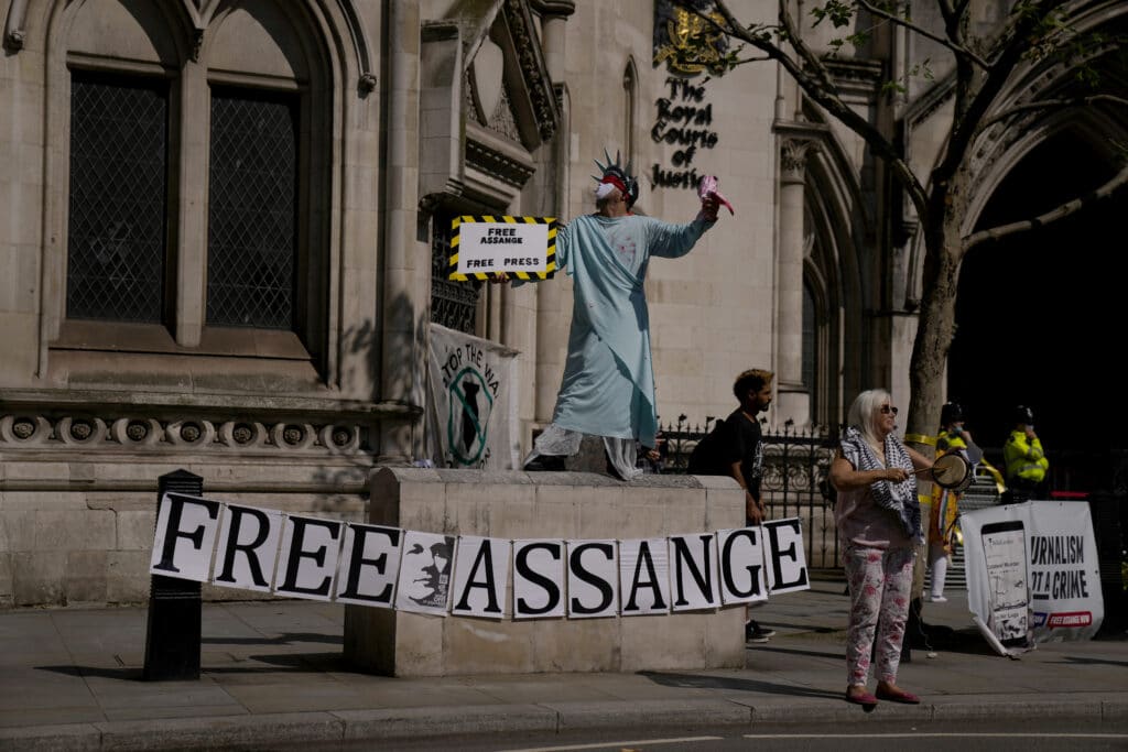 A supporter of WikiLeaks founder Julian Assange demonstrates dressed as the Statue of Liberty,